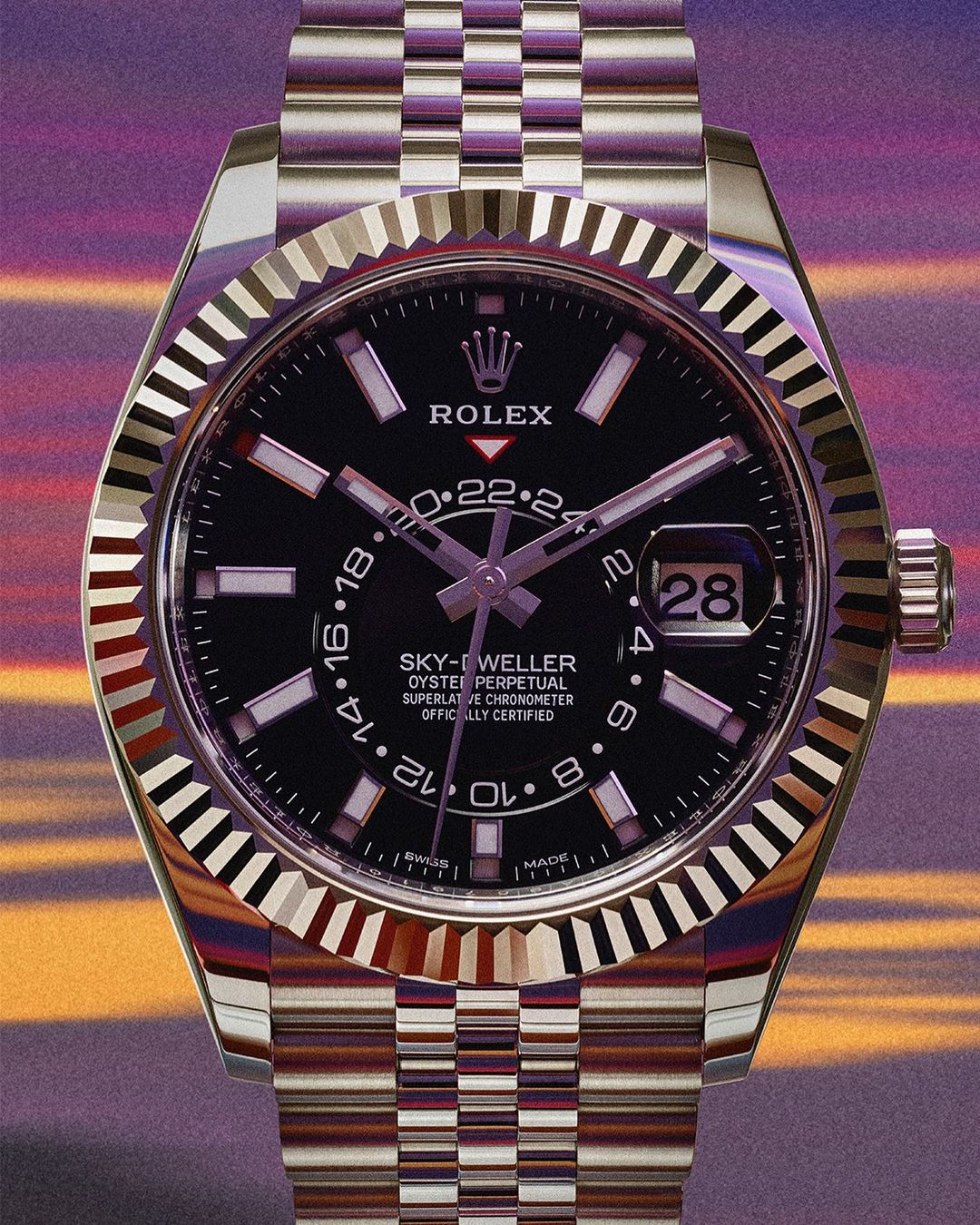 Close-up shot of a silver Rolex Sky-Dweller watch with a black face, showcasing its intricate design and luxurious craftsmanship.