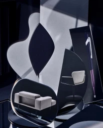 Abstract product still life photography featuring geometric panels, curved mirrors, and miniature modern furniture pieces.