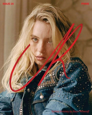 Close-up portrait of a blond woman, Sydney Sweeney, wearing a denim jacket with embellishments against a neutral background.