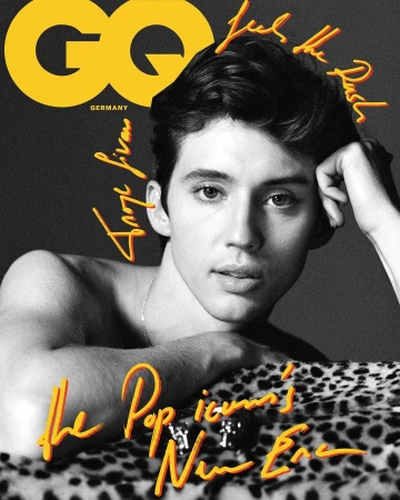 GQ magazine cover featuring a young man with dark hair, resting his head on his hand and posing on a leopard print surface.
