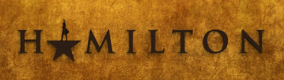 Text graphic reading Hamilton in dark serif letters against a textured metallic gold background with a star replacing the letter A.