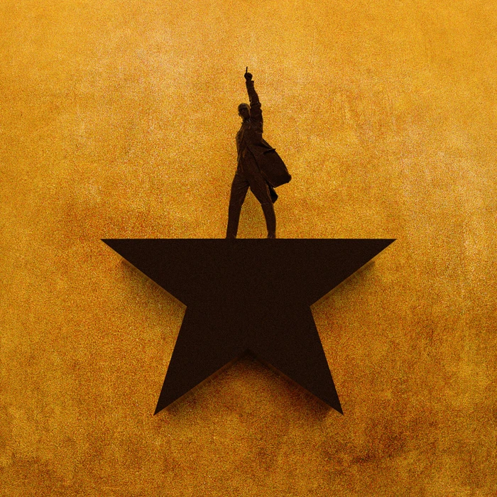 Figure standing atop a large black star against a textured golden yellow wall, raising one hand.