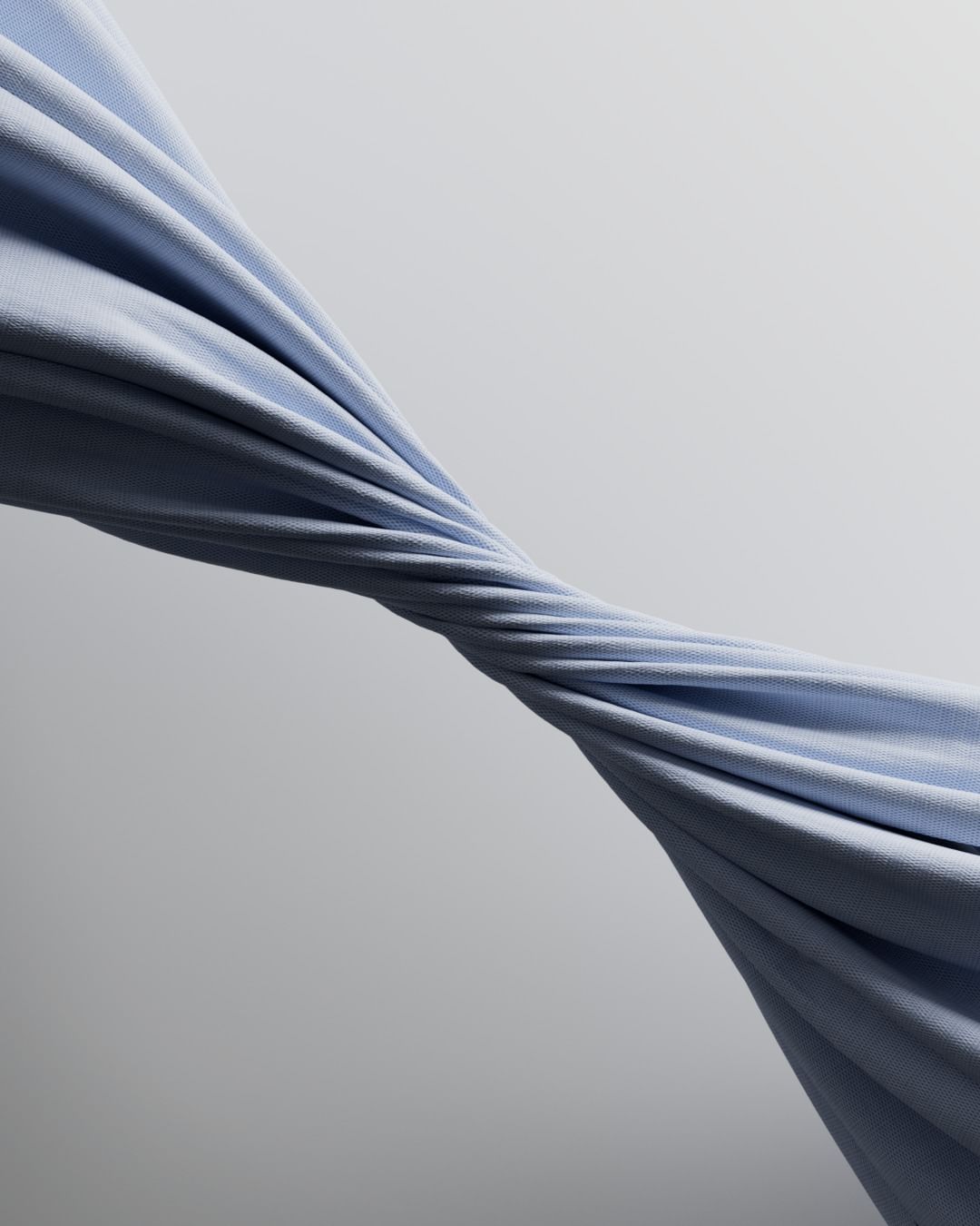 Abstract photo of a light blue fabric twisting in the center against a gradient gray backdrop. Soft, diffused lighting showcases the material.