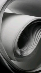 Monochrome abstract close up of tightly rolled curved paper layers forming a dynamic spiral tunnel.