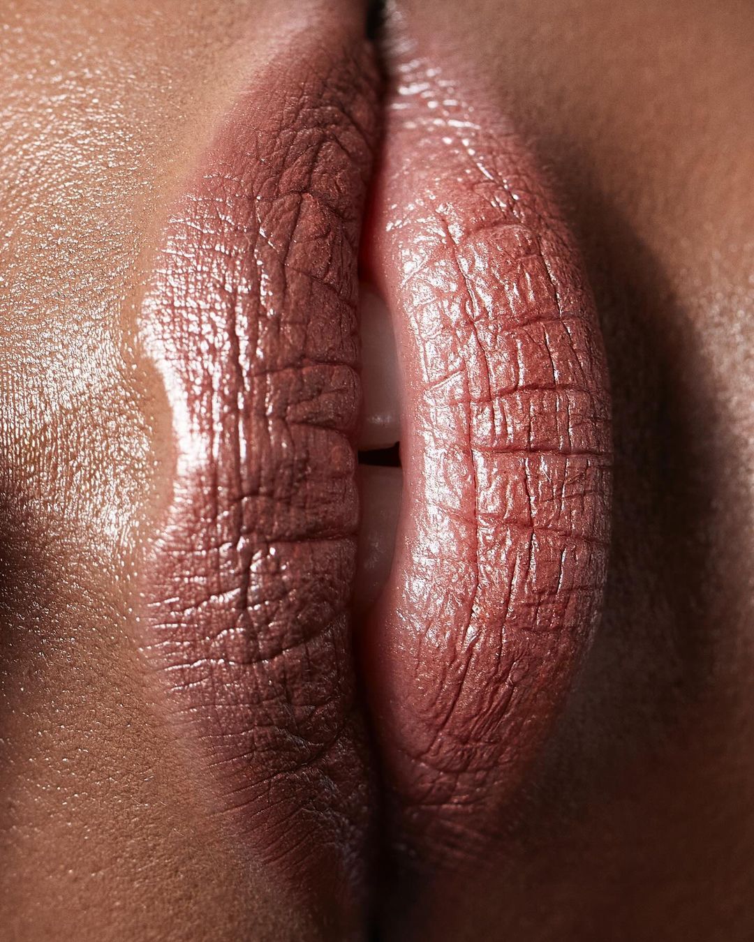 Close-up studio shot of adult female's mouth and lips with lipstick, emphasizing textures and natural skin tones in beauty aesthetic.