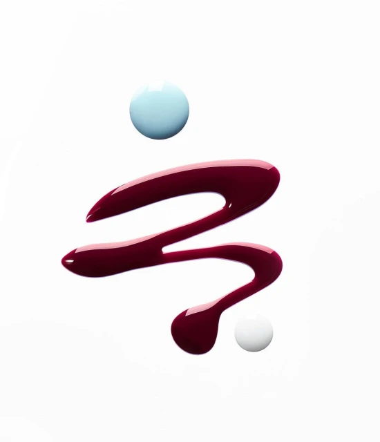 Swirls of glossy red and blue nail polish against a white background create an abstract beauty aesthetic with a modern, minimalist feel.
