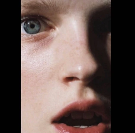 Close-up portrait of a person with blue eyes and freckles, photographed by Suffo Moncloa in New York.