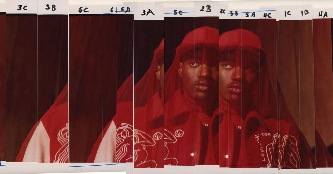 A photo of a person wearing a red cap and jacket with white graphics, presented as a strip of film with visible borders and numbering.
