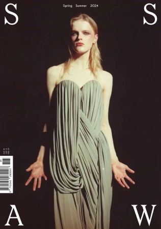 Fashion magazine cover featuring a model in an elegant grey dress against a dark background, with overlaid magazine title text and barcode.
