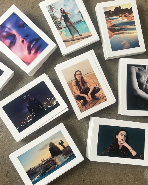 Collection of printed fashion photographs, showcasing diverse models in various outdoor settings, highlighting editorial style and visual storytelling.