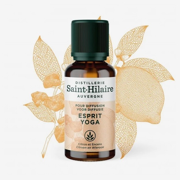 A bottle of Saint-Hilaire Esprit Yoga essential oil on a white background, featuring botanical lemon and floral accents.