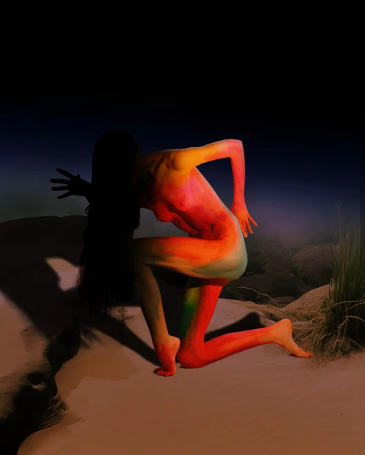 Woman kneeling with body paint in sandy outdoor setting with dark background, shot in portrait orientation with diffused lighting.