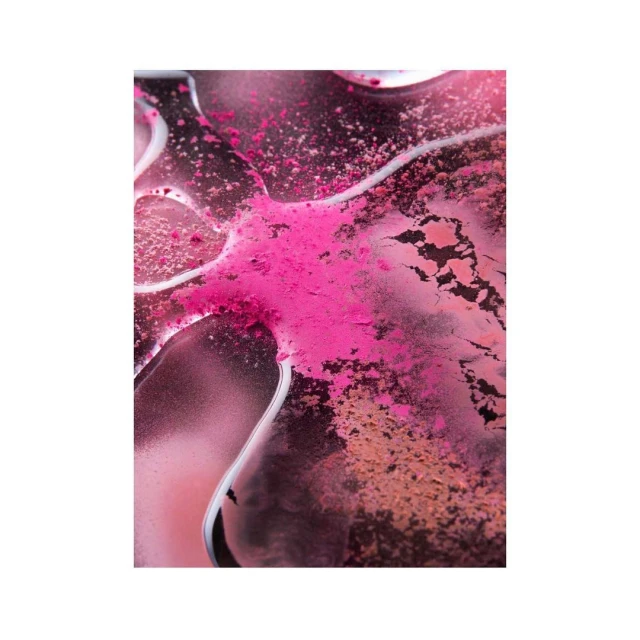 Close-up of pink and brown powder pigments on a glossy surface, creating an abstract and textured cosmetic product shot.