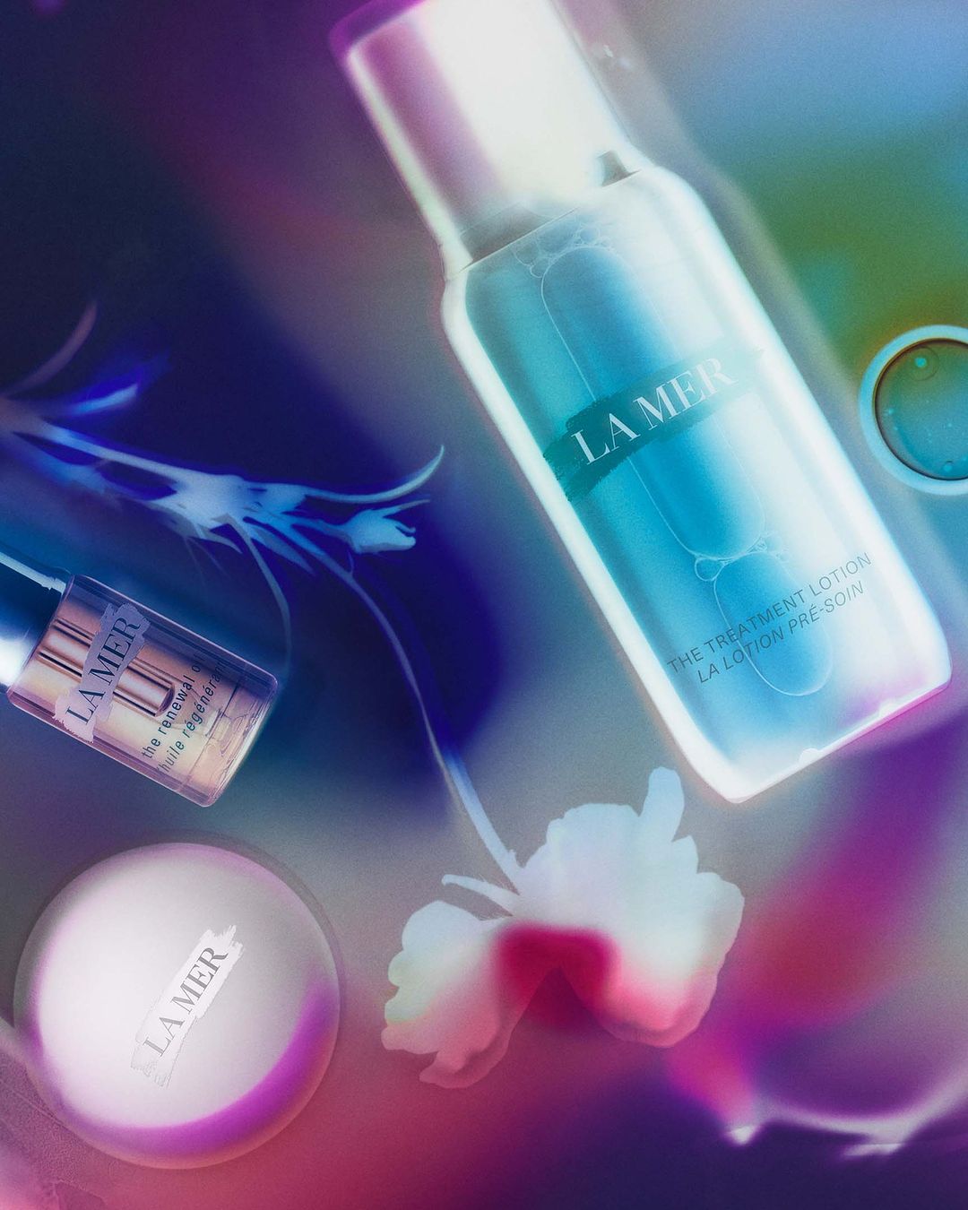 La Mer skincare products including treatment lotion, face cream, and oil displayed with floral elements, promoting beauty and skincare.