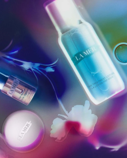 La Mer skincare products including treatment lotion, face cream, and oil displayed with floral elements, promoting beauty and skincare.