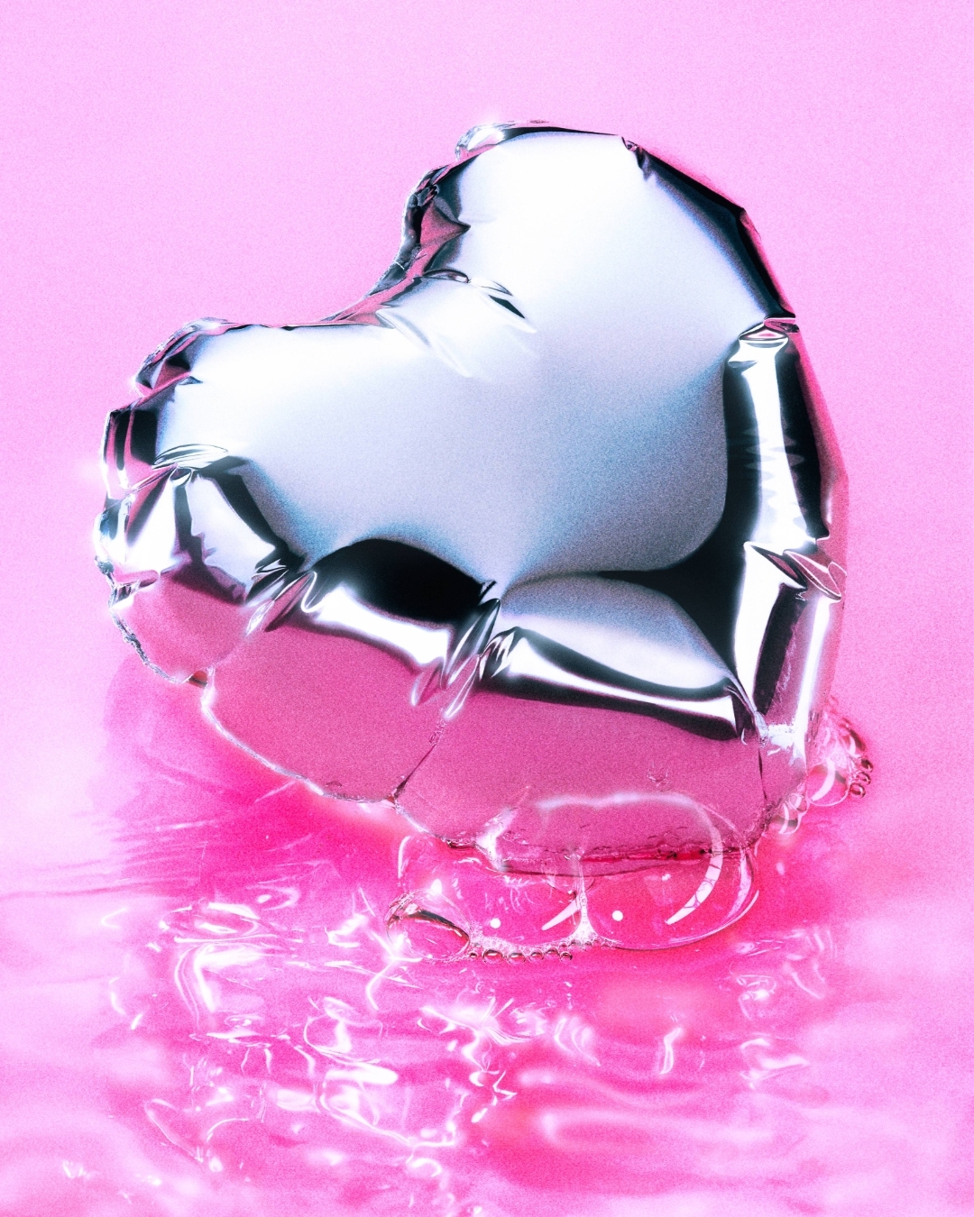 Silver heart-shaped balloon floating on a pink reflective surface. The balloon reflects the surrounding light and colors with a metallic sheen.