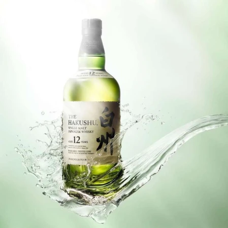 Bottle of Hakushu Japanese whisky with water splash effect on a light green background, product shot for advertising and marketing.