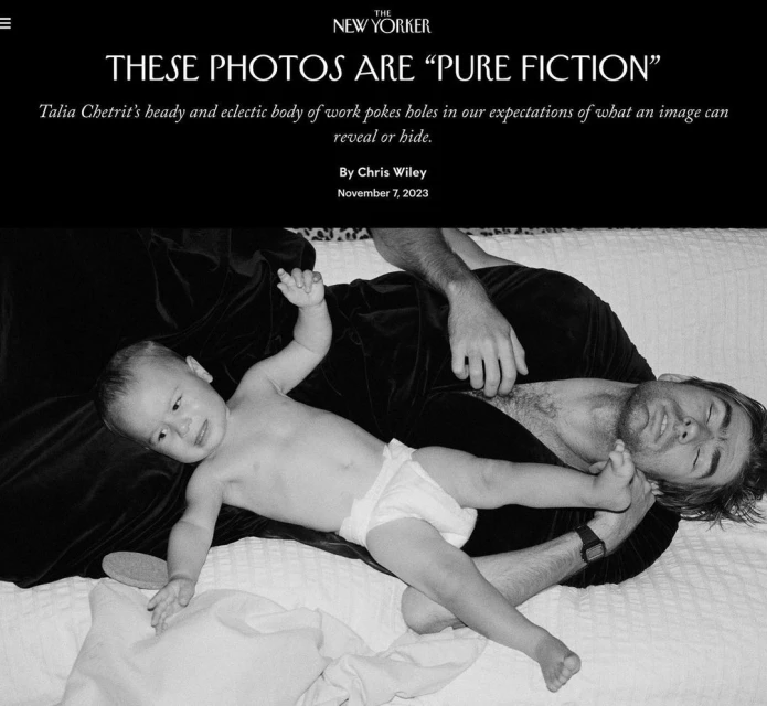 Black and white studio portrait of a baby in diaper with arms up lying on an adult male on a bed in a studio setting.
