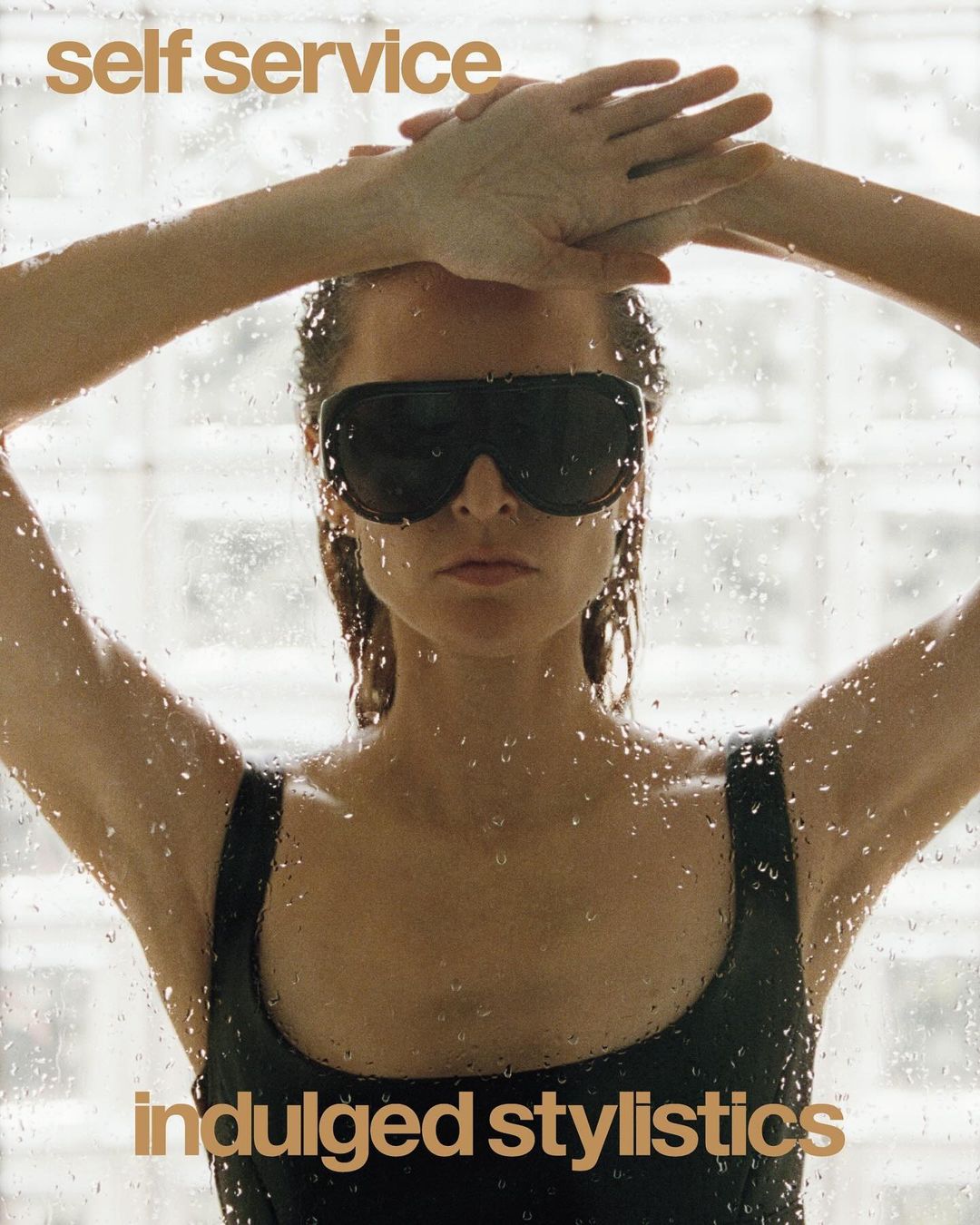 A woman in sunglasses stands in front of a textured glass, with the magazine title 'Self Service' visible at the top left of the image.