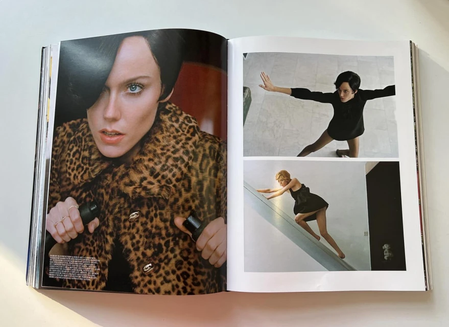 Open magazine featuring a woman with short dark hair in a leopard print coat, alongside two photos of dancers in black outfits.