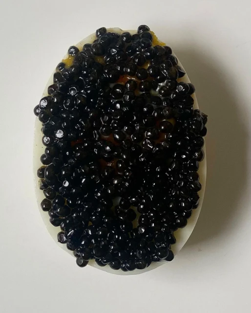 Caviar tops a halved boiled egg, creating a striking contrast between the white egg and the shiny black pearls.