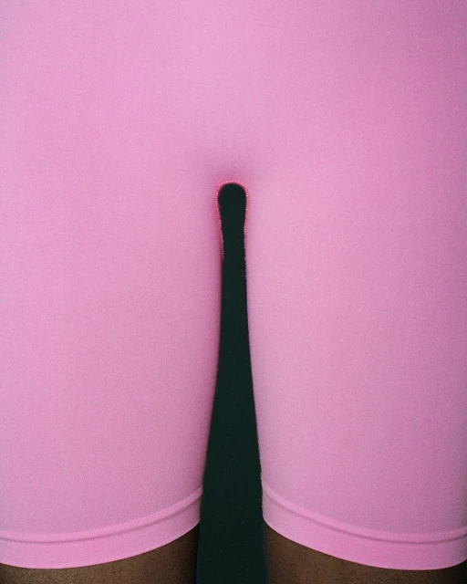 Close-up of person in pink shorts with shadow on dark green background, fashion, athletic wear, fitness apparel, legs.