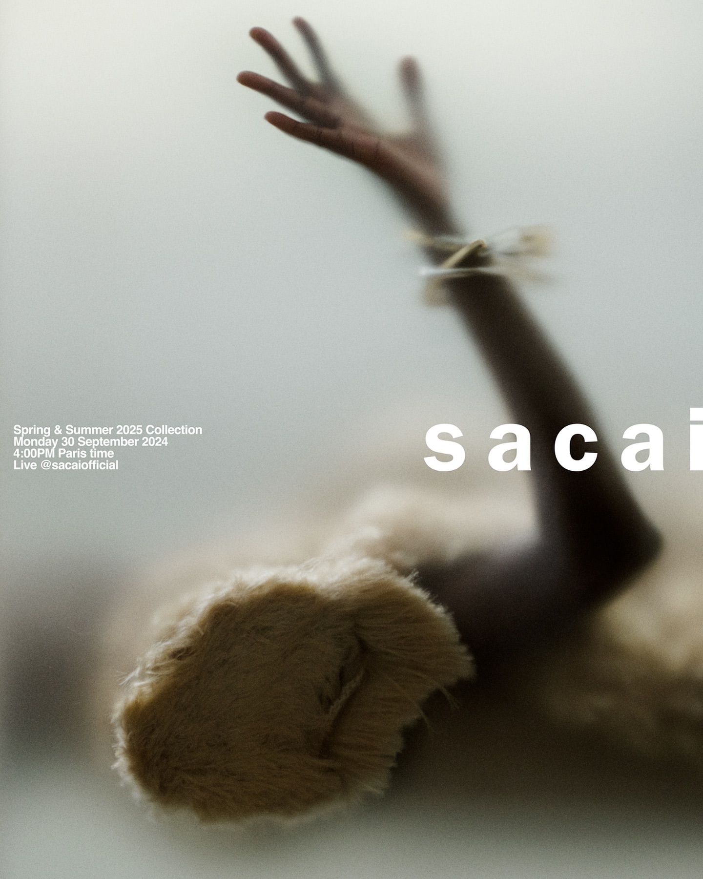 Fashion visual for Sacai's Spring & Summer 2025 Collection features a model's hand and fur garment, soft textures, and diffused light.