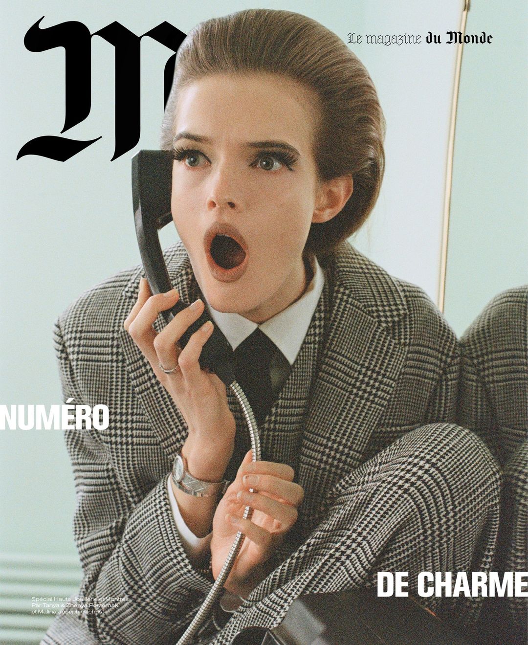 Magazine cover featuring a woman in a plaid suit holding a phone, with an open-mouthed expression and vintage hairstyle.