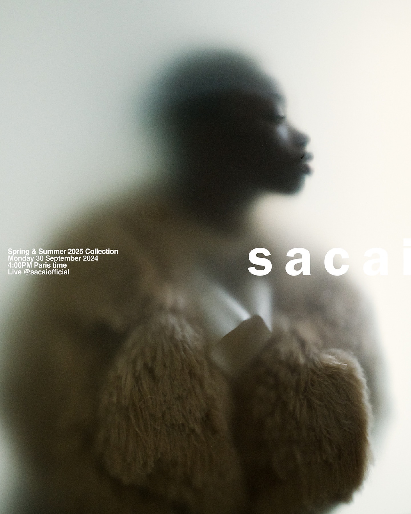 Fashion advertisement featuring an African-descent female model wearing fur outerwear and 'sacai' text, through a frosted glass.