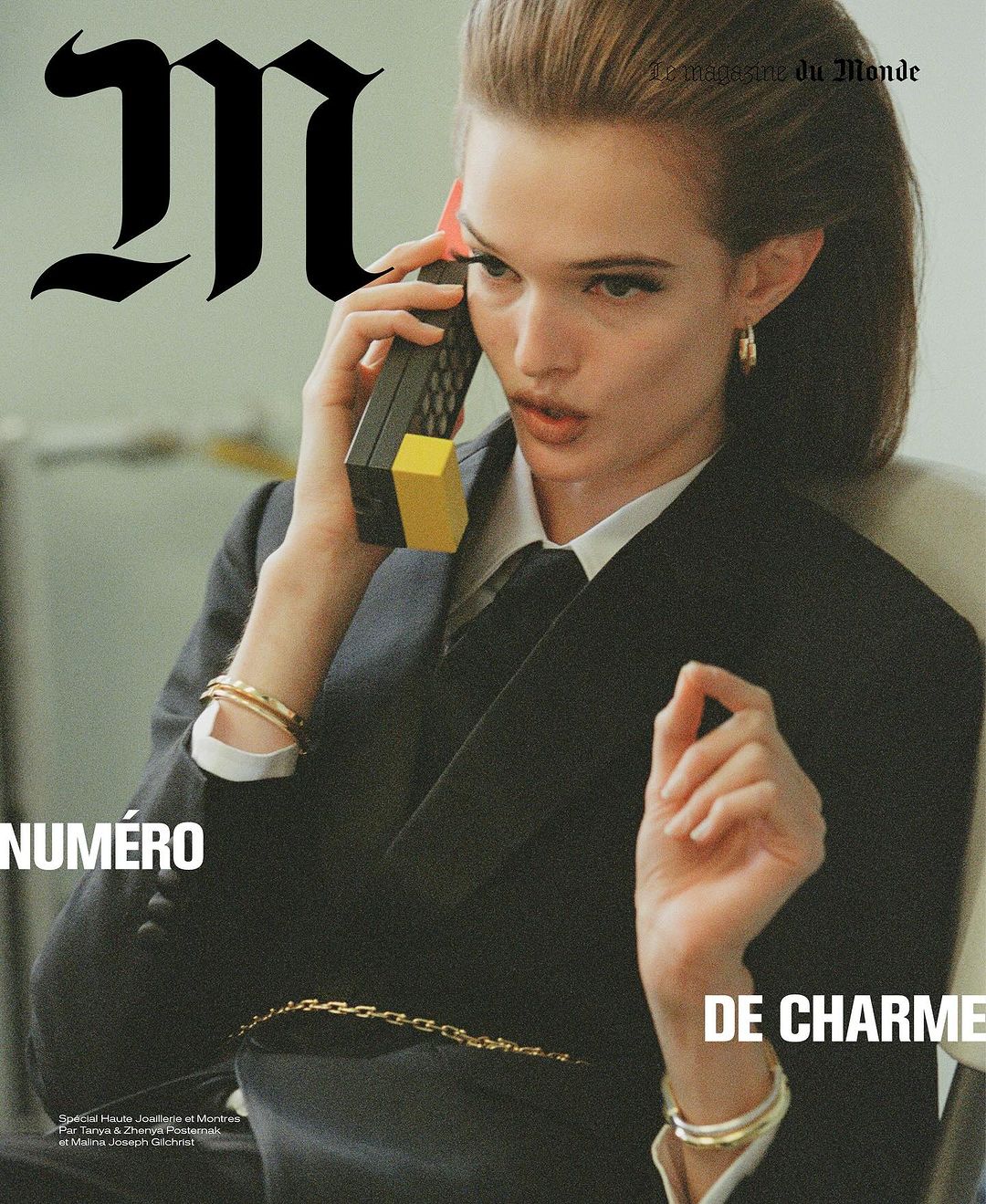 Fashion editorial cover featuring a woman in a suit using a retro brick phone, with 'M le magazine du monde' text overlay.