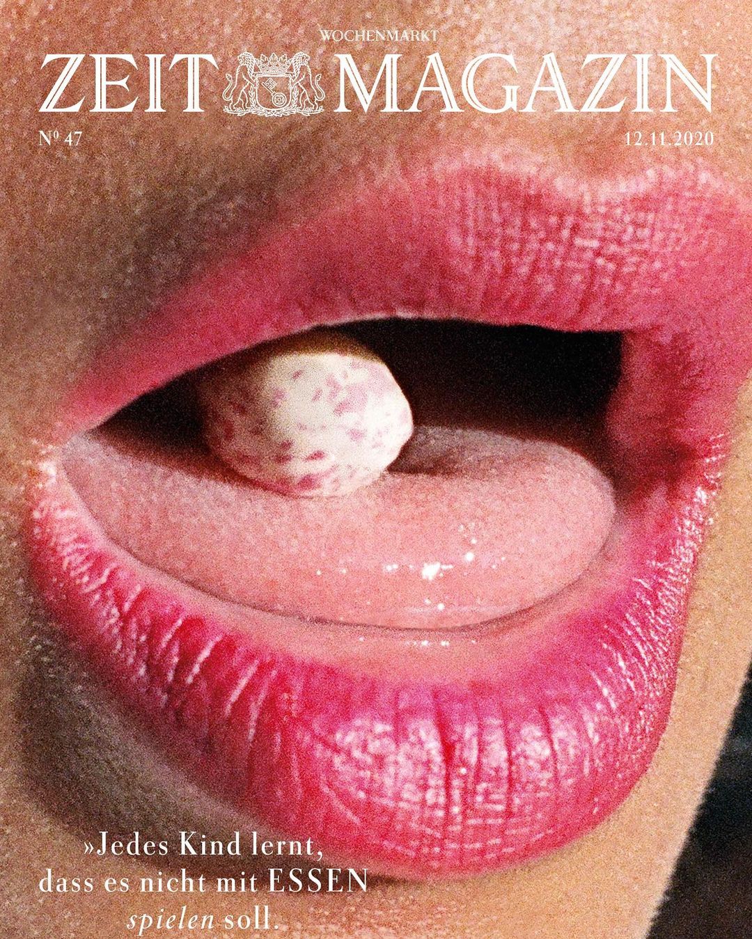 Close-up of open mouth with red lipstick, tongue out, holding a white pill with red spots, and a magazine cover above it.