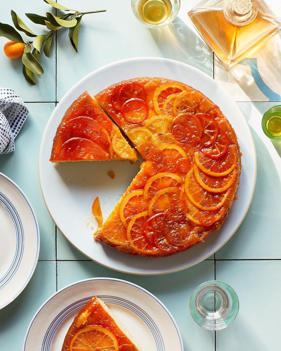 Overhead shot of a sliced orange citrus upside-down cake served on a white plate, showcasing the caramelized fruit topping.