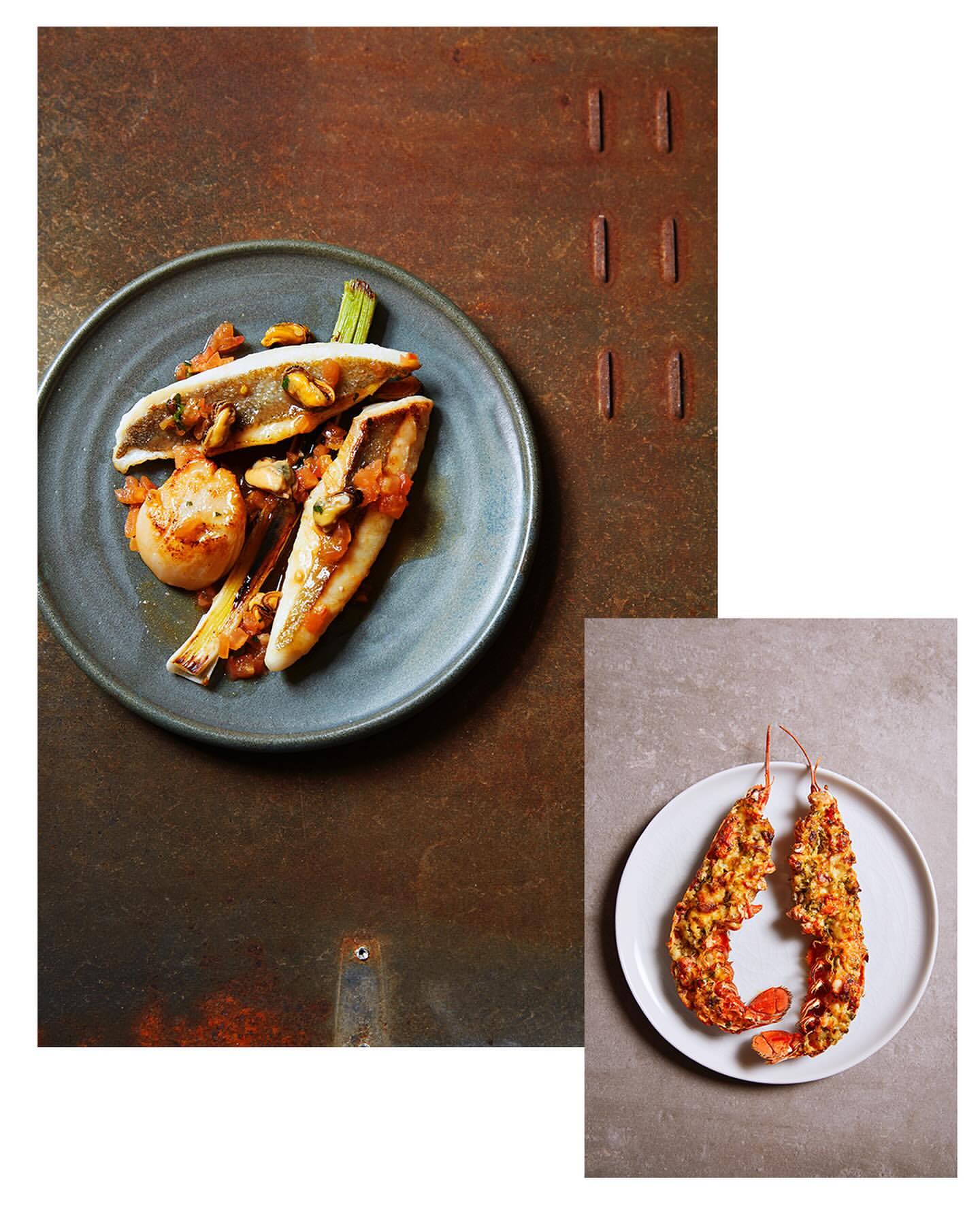 Food photography of seafood plates with grilled fish and lobster tails on a rustic textured surface, in a studio setting.