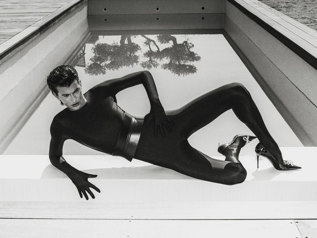 Man wearing a black bodysuit and heels lying by a swimming pool in London shot by Tarek Mawad