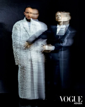 Editorial fashion image by Tarek Mawad showing two models with multiple exposure motion blur against a dark background.