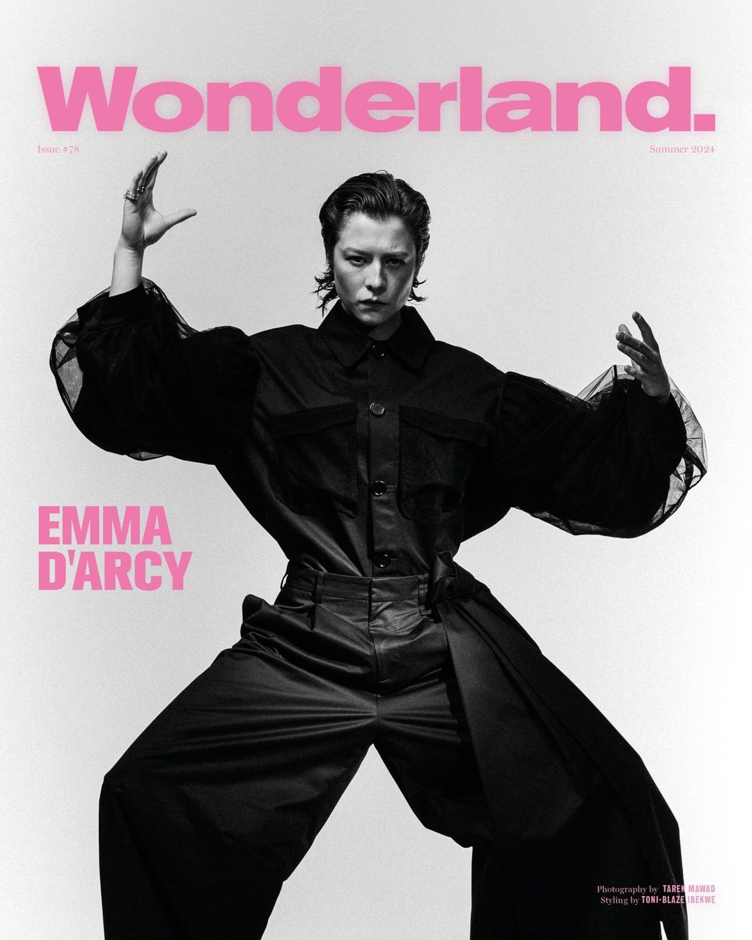 Emma D'Arcy poses on the cover of Wonderland magazine in a wide stance wearing a black jumpsuit against a stark white background.
