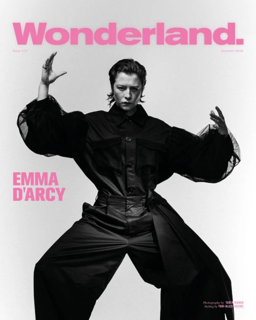 Emma D'Arcy poses on the cover of Wonderland magazine in a wide stance wearing a black jumpsuit against a stark white background.