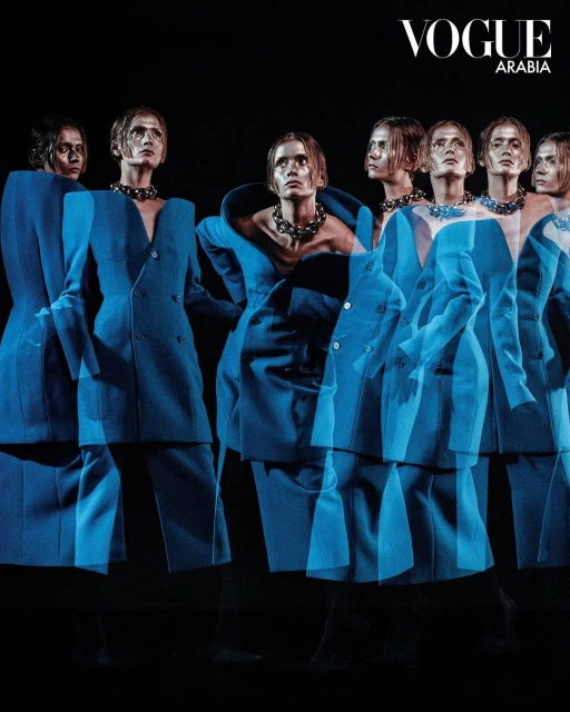 Fashion editorial featuring multiple exposures of a model in a blue suit and chunky necklace, set against a dark background.