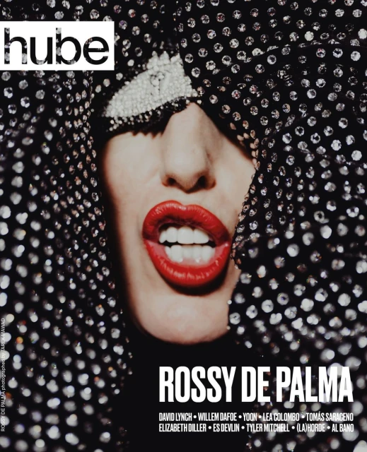 Close-up studio shot of Rossy de Palma magazine cover featuring a woman with bright red lipstick wearing a sequined head covering.
