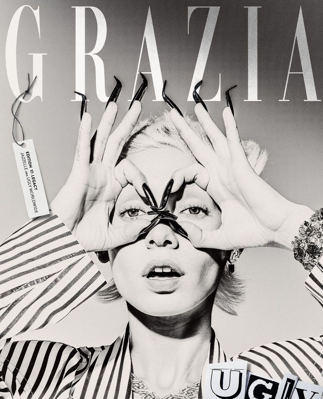 Black and white fashion editorial cover with a woman making a frame around her eyes with long nails and Grazia magazine logo.