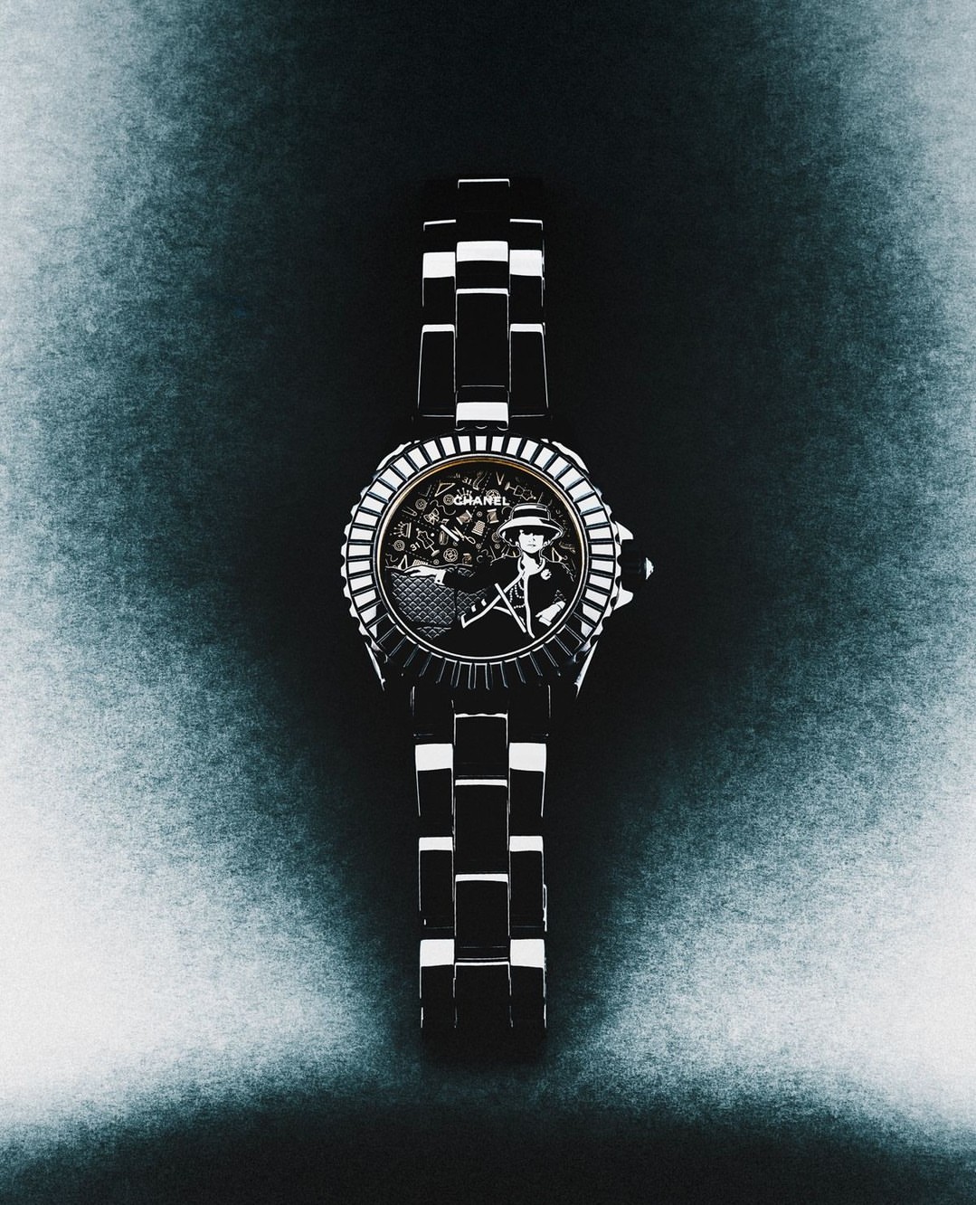 High-angle close-up of a designer wristwatch with black and white band, showcasing Chanel logo, against a mottled dark blue background.