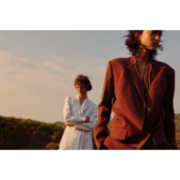 Two models outdoors wearing structured blazers against a landscape background by Tassili Calatroni
