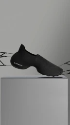 A black Givenchy futuristic slip-on shoe suspended by thin wires above a grey pedestal in a minimalist studio setting.