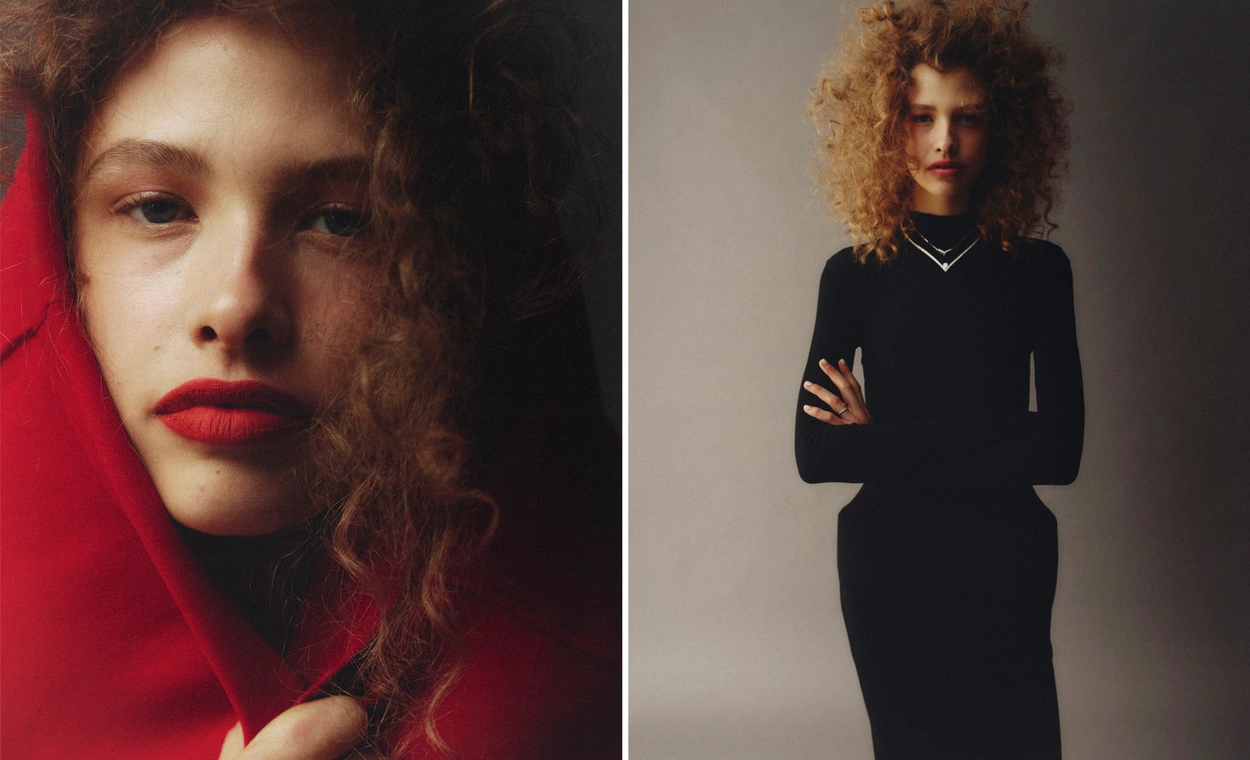 Model with voluminous curly hair wearing a black long-sleeve top against a neutral studio background