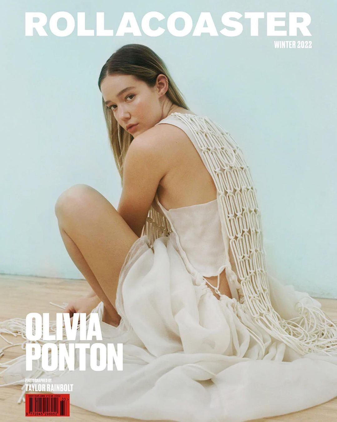 Magazine cover featuring Olivia Ponton, posing in a white dress with an open-weave shawl against a pale blue background indoors.