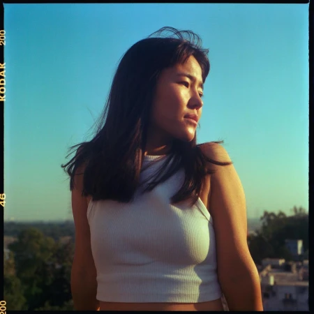 Woman in a white ribbed crop top against a clear blue sky background captured by photographer Tenzin Lhagyal