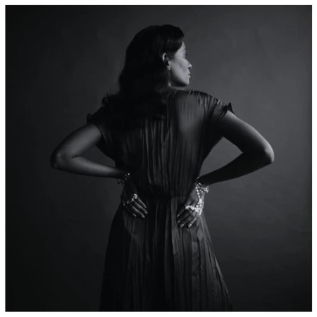 Monochrome portrait of a woman in a pleated dress wearing intricate hand jewelry, shot by Tenzin Lhagyal