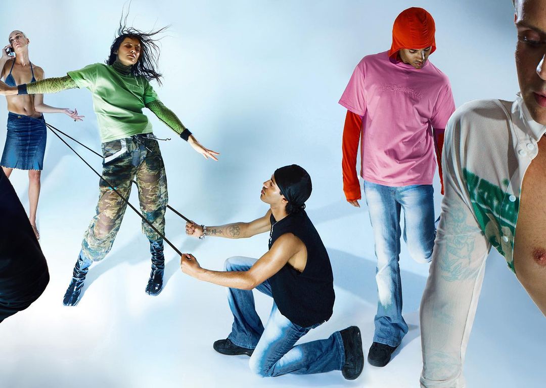 Fashion editorial image featuring a group of young adults in a brightly lit studio wearing various styles of streetwear and denim.