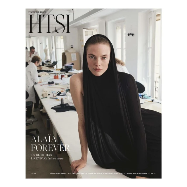 Magazine cover featuring a woman in a black headscarf with neutral expression, set against a workspace with sewing equipment.