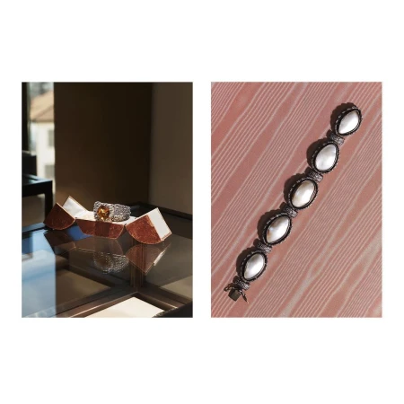 A ring with an amber-colored gemstone in a display case, and a mother-of-pearl bracelet on a pink wood background.